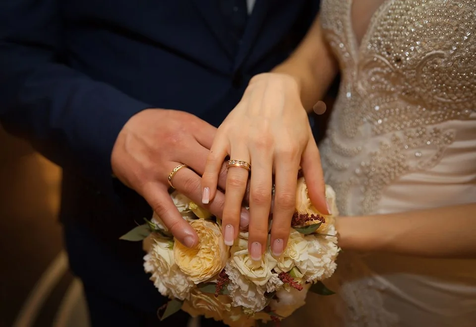Обручальные кольца на руках жениха и невесты